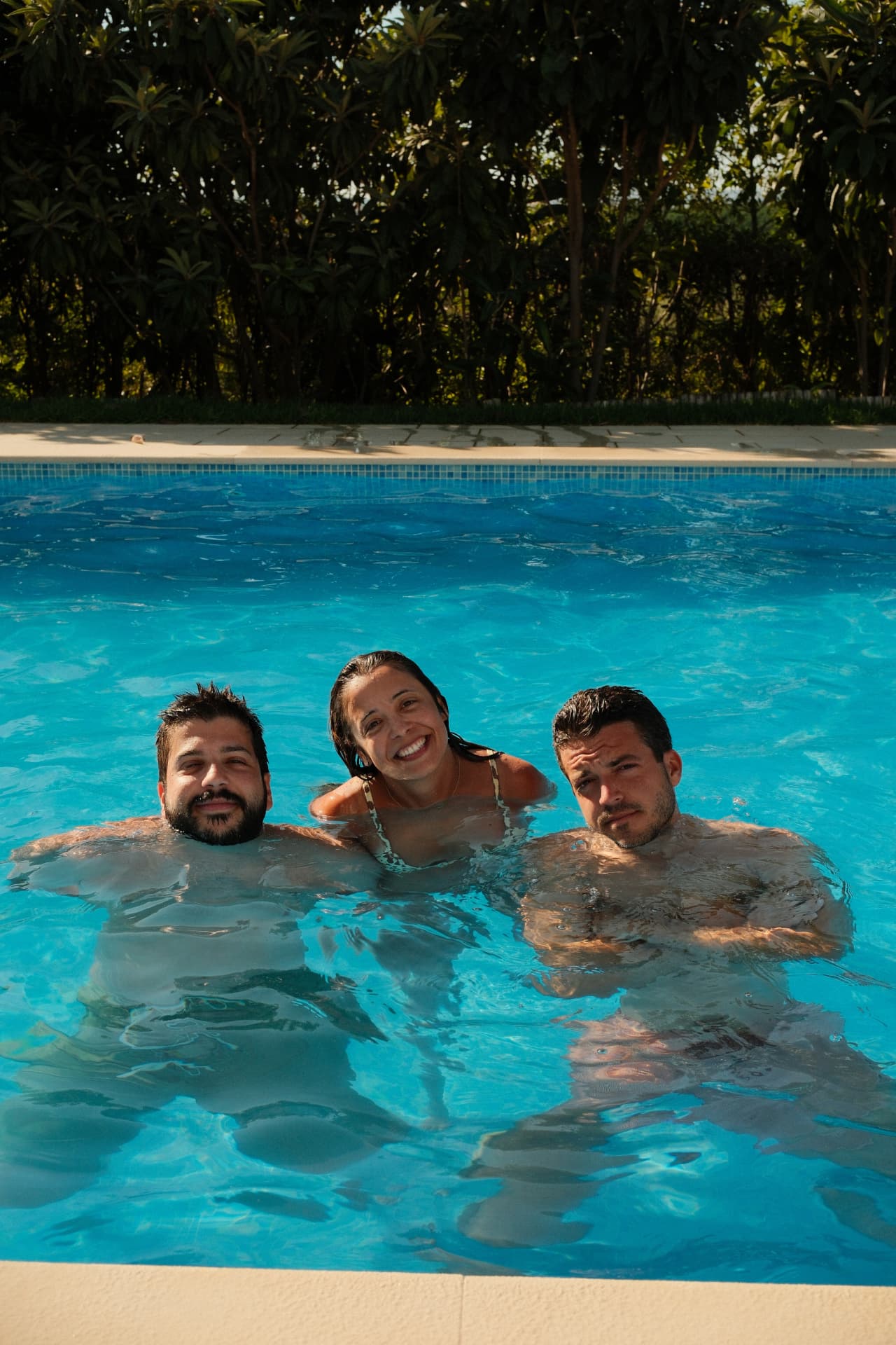 Three friends floating in the pool